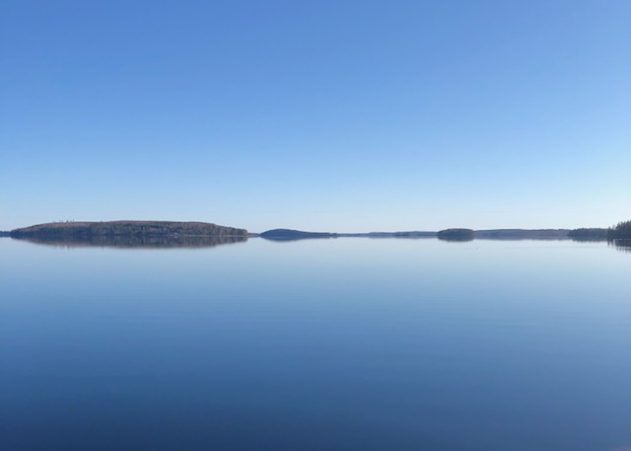 Tyyni järvimaisema ja sininen taivas